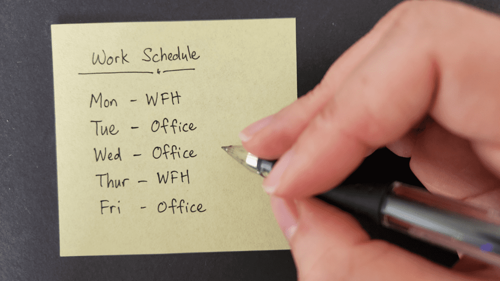 Writing a schedule on a sticky note.